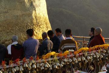 Buddhisten kleben Blattgold an den goldenen Felsen
